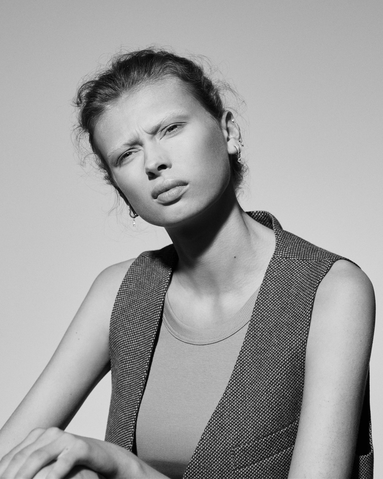 Black and white portrait of a person squinting and looking serious.