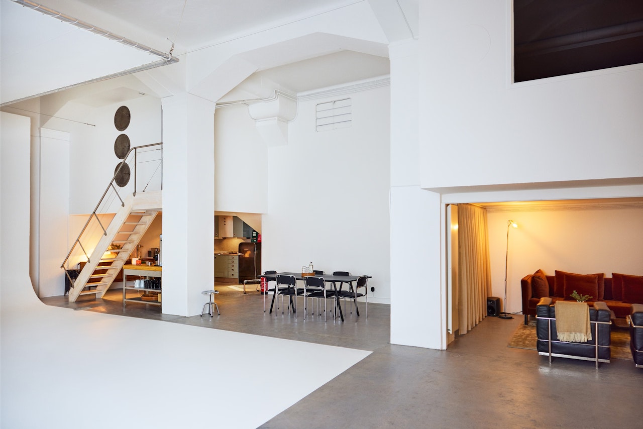 Spacious white photo studio with cameras and props.