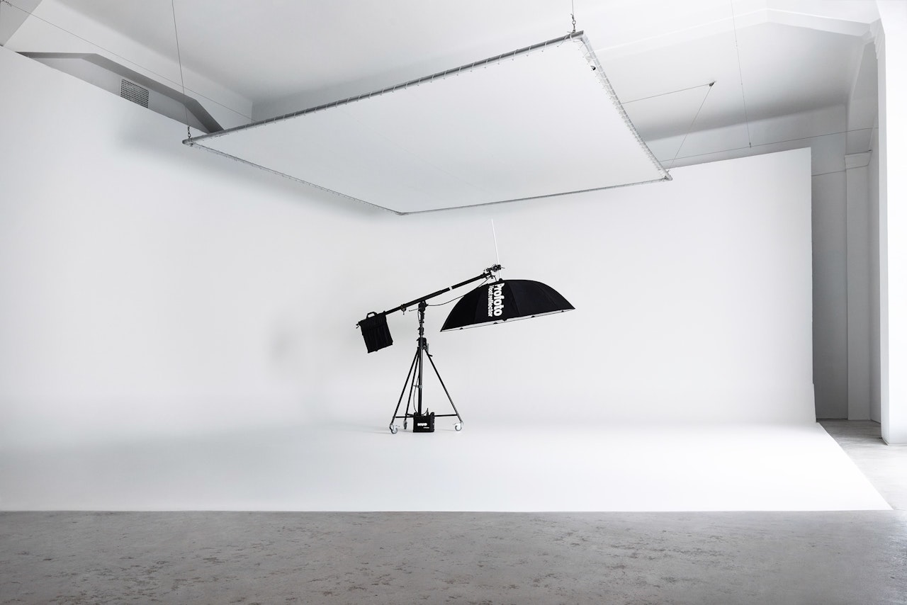 Large white photography studio with a camera crane.