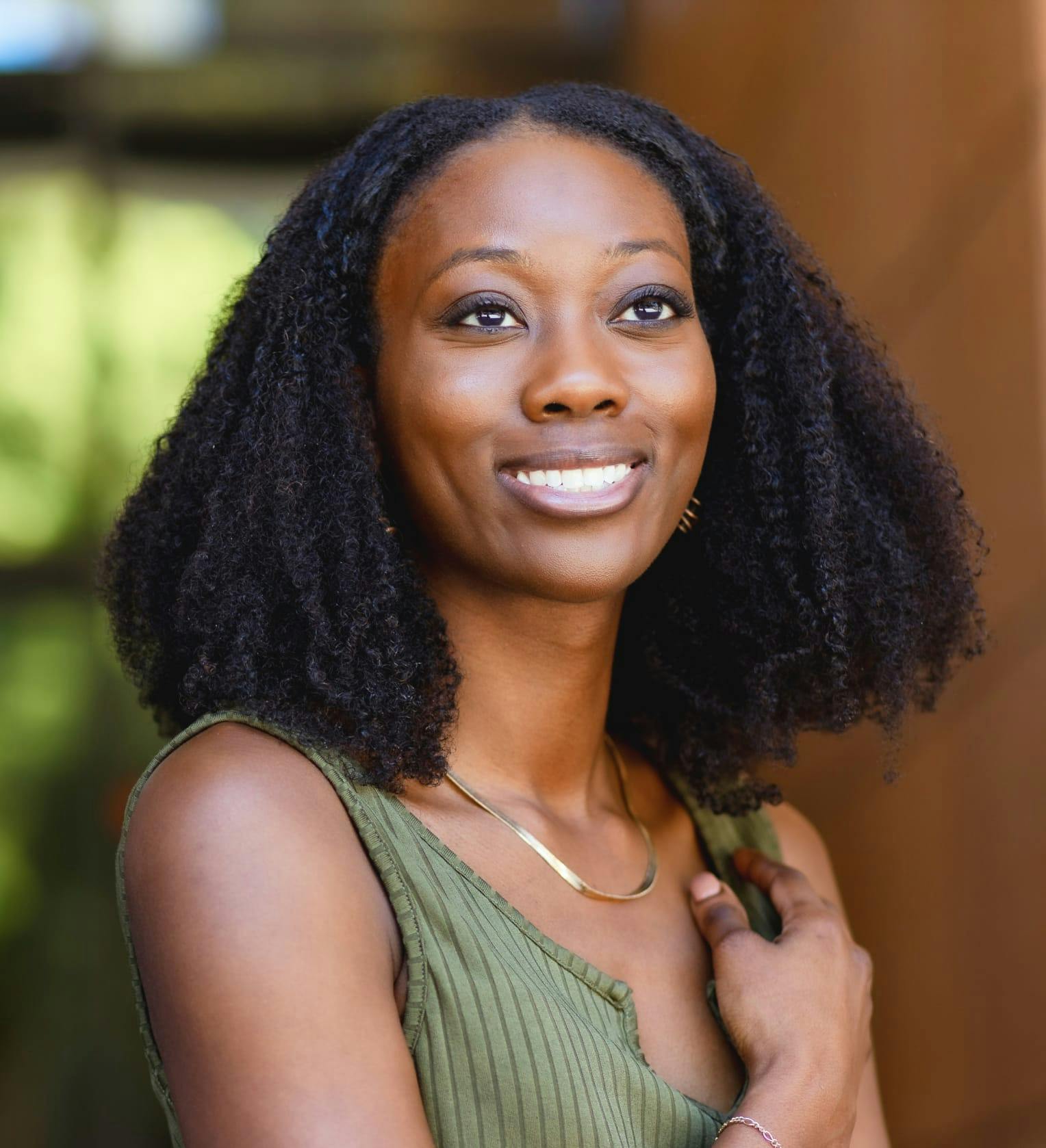 woman smiling and wearing a green top