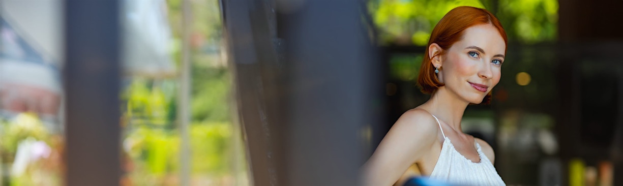 woman in white top posing outdoors