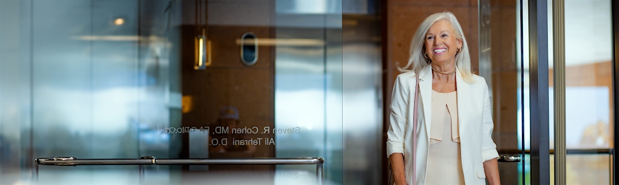woman in white blazer entering office