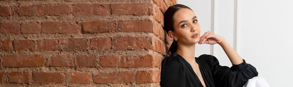woman resting against brick wall