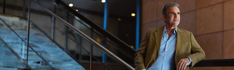 Man leaning on wall by stairs