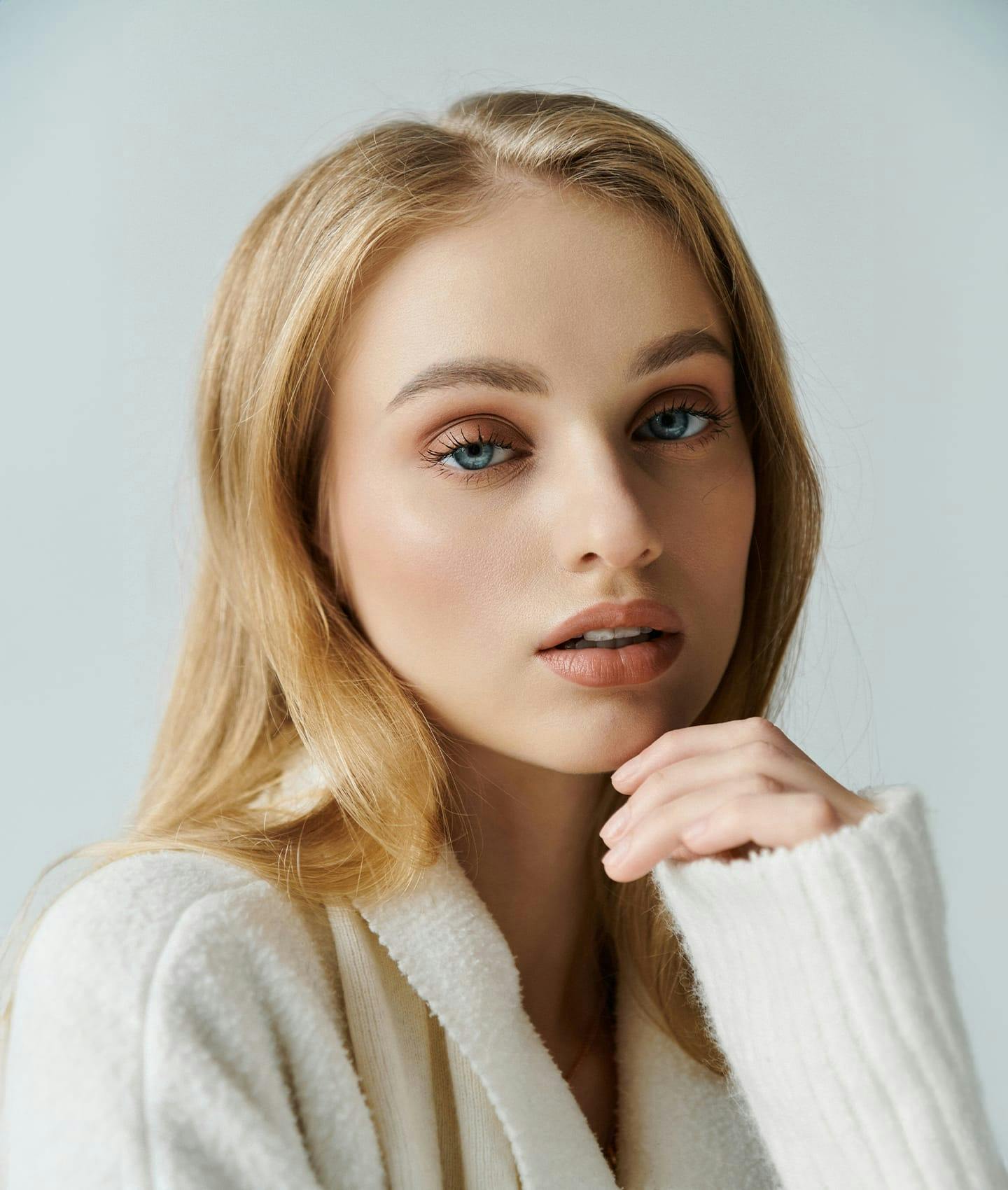 woman in sweater resting her hand on her chin