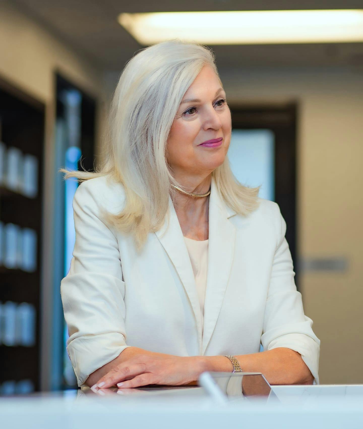 Woman in white jacket at front desk