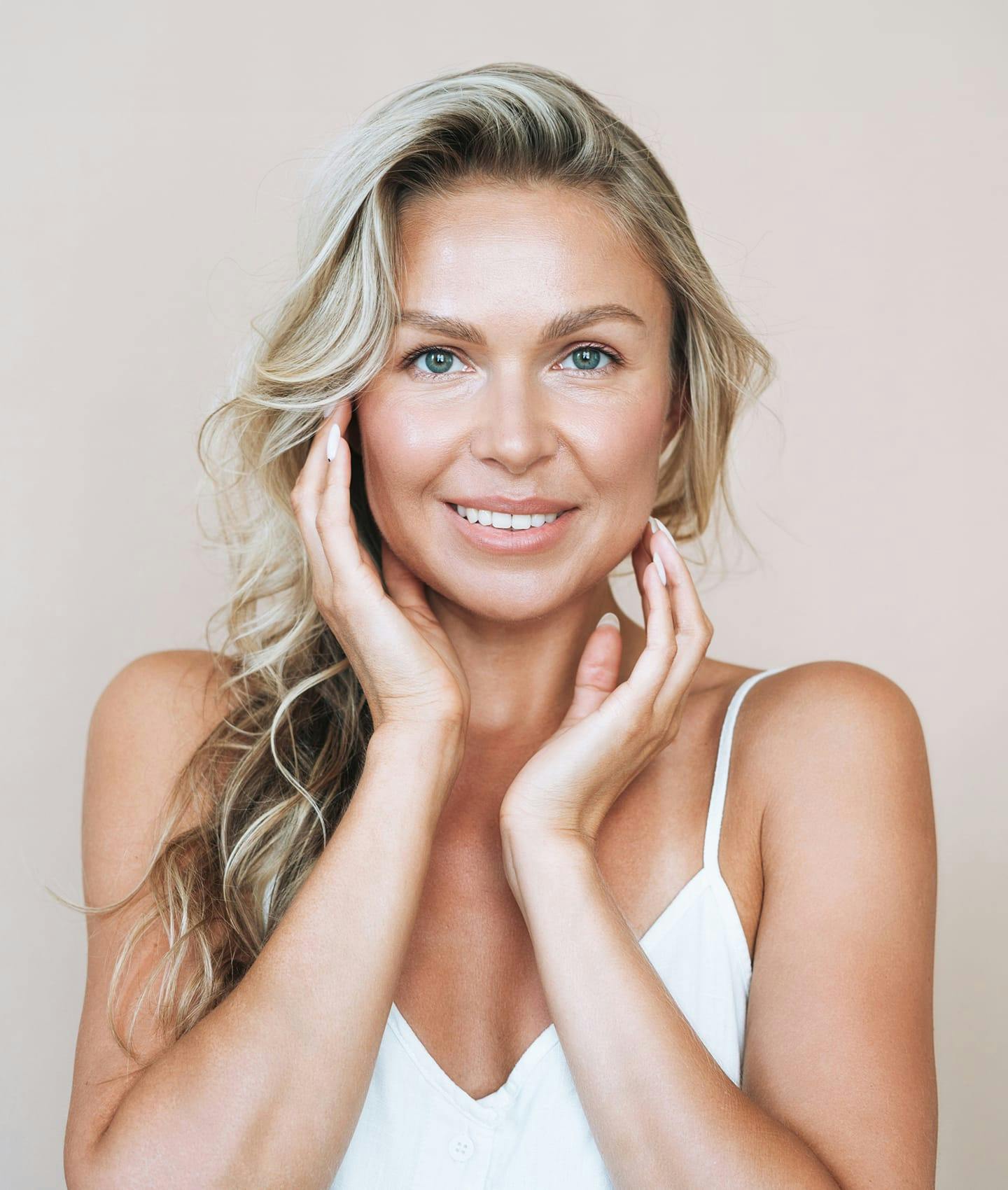 woman smiling and touching cheeks