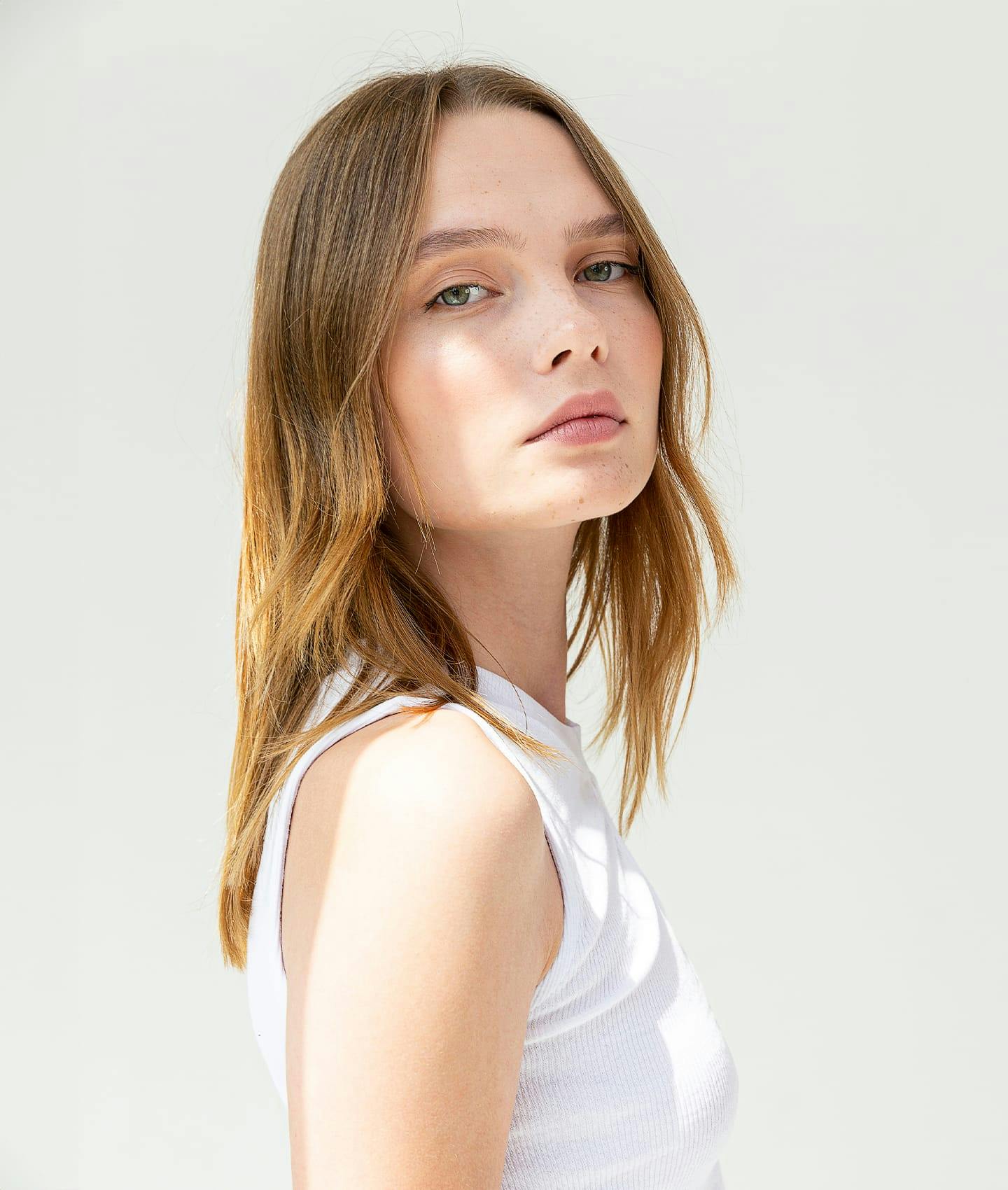 woman in white top looking over shoulder