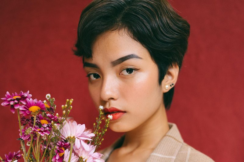 Portrait of a Woman Holding Flowers Looking Directly at the Camera