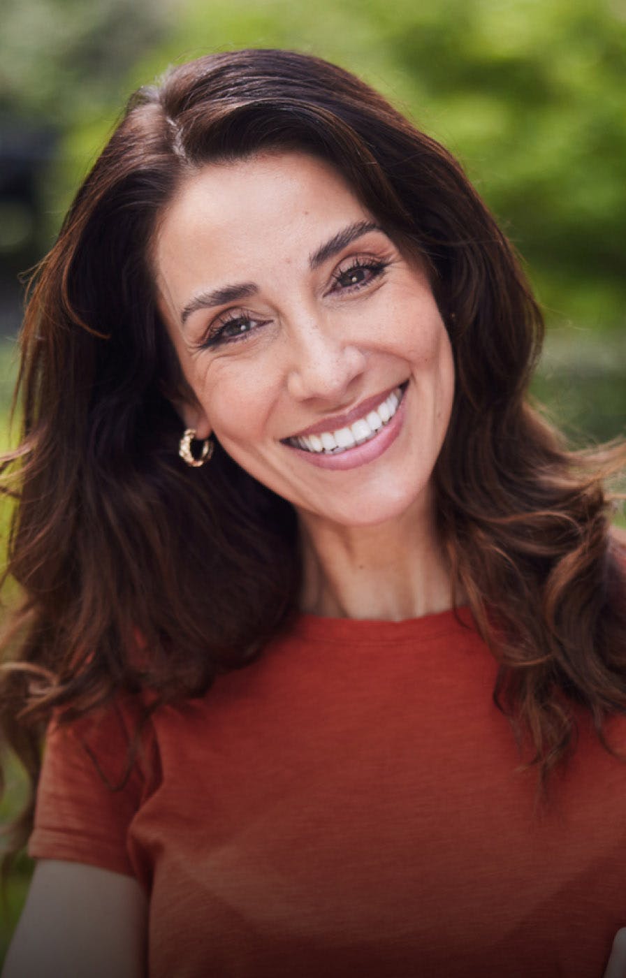 woman with long brown curly hair smiling