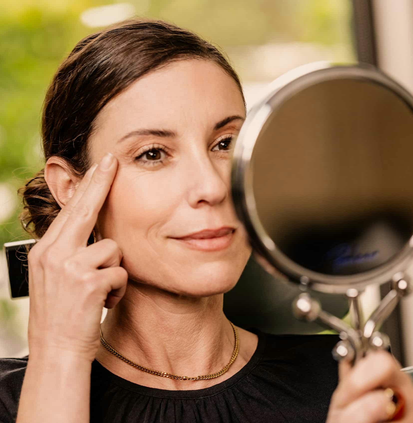 Woman looking in mirror smiling