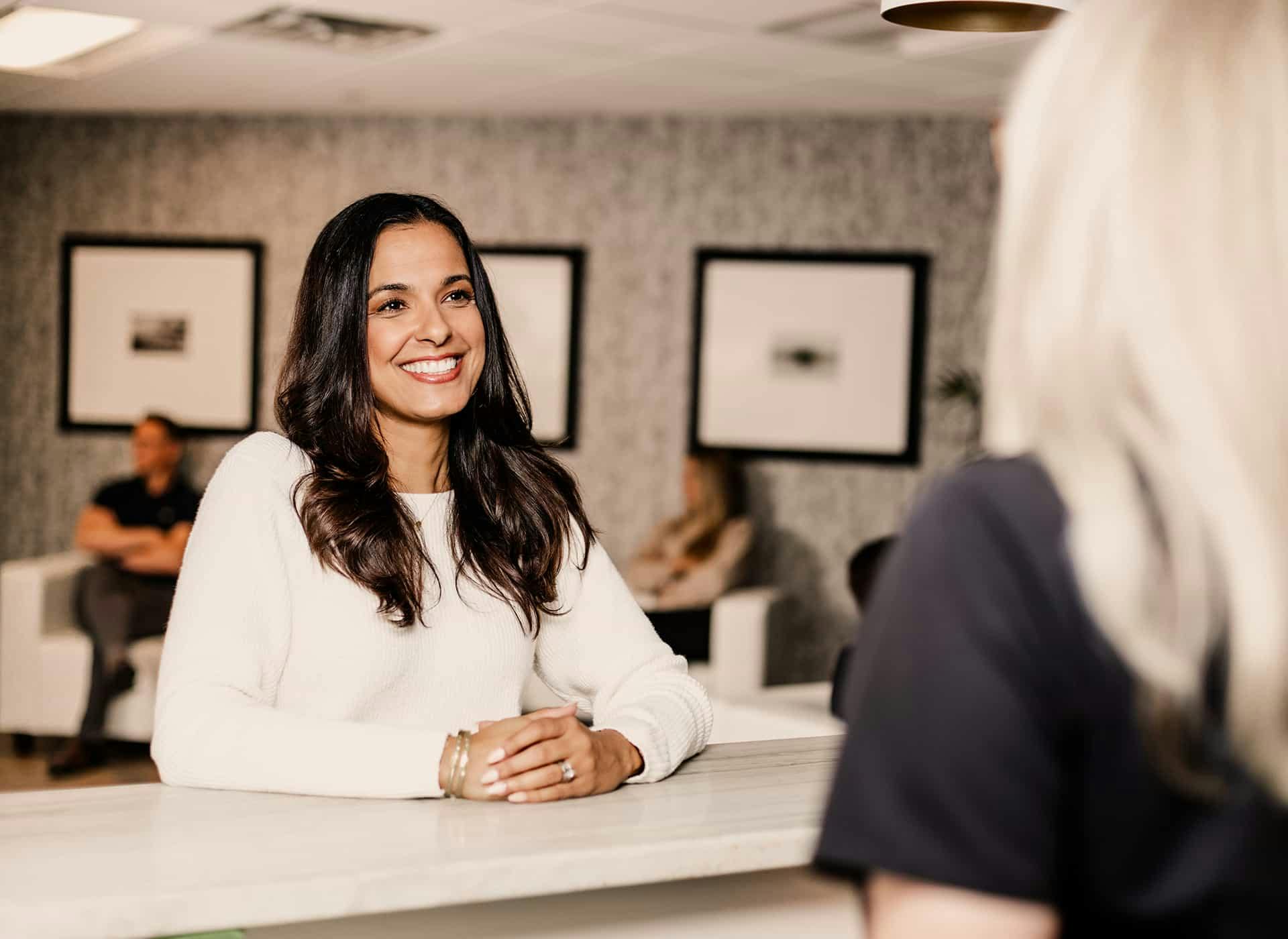 Woman standing at reception desk smiling