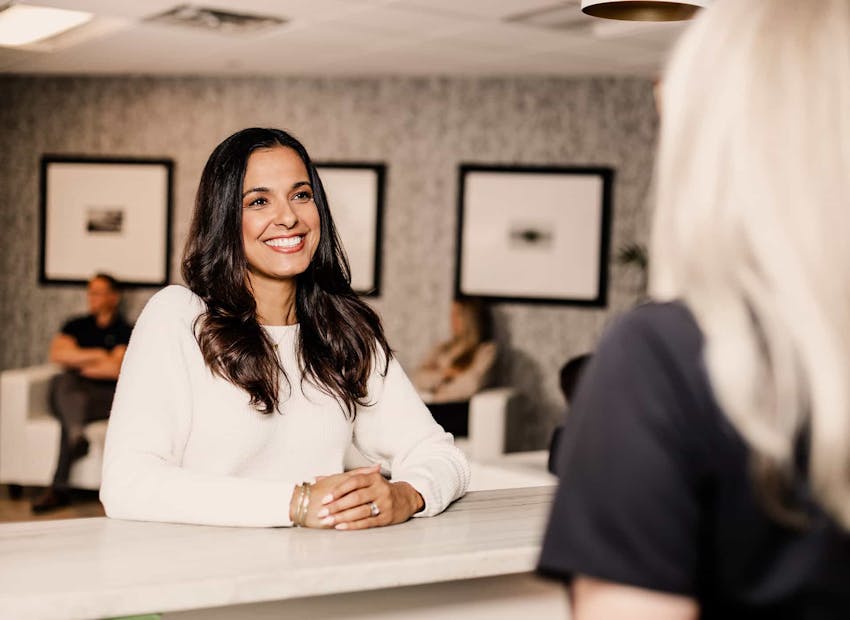 Woman standing at reception desk smiling