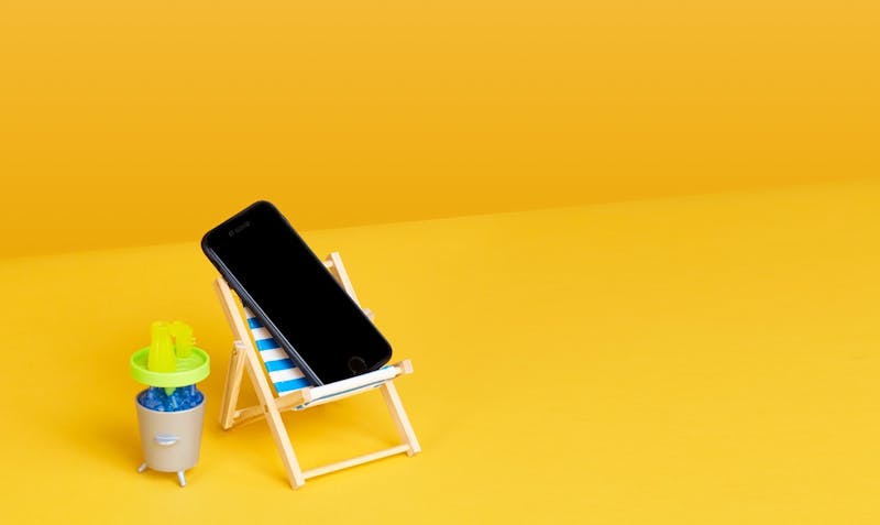 Ein Handy im Sonnenstuhl symbolisiert passiv investieren
