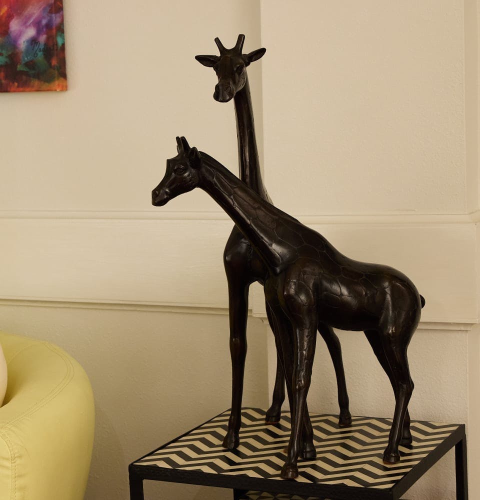 2 black giraffe statues on side table