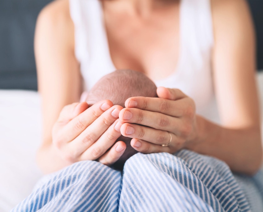 woman holding babies head while its in her lap