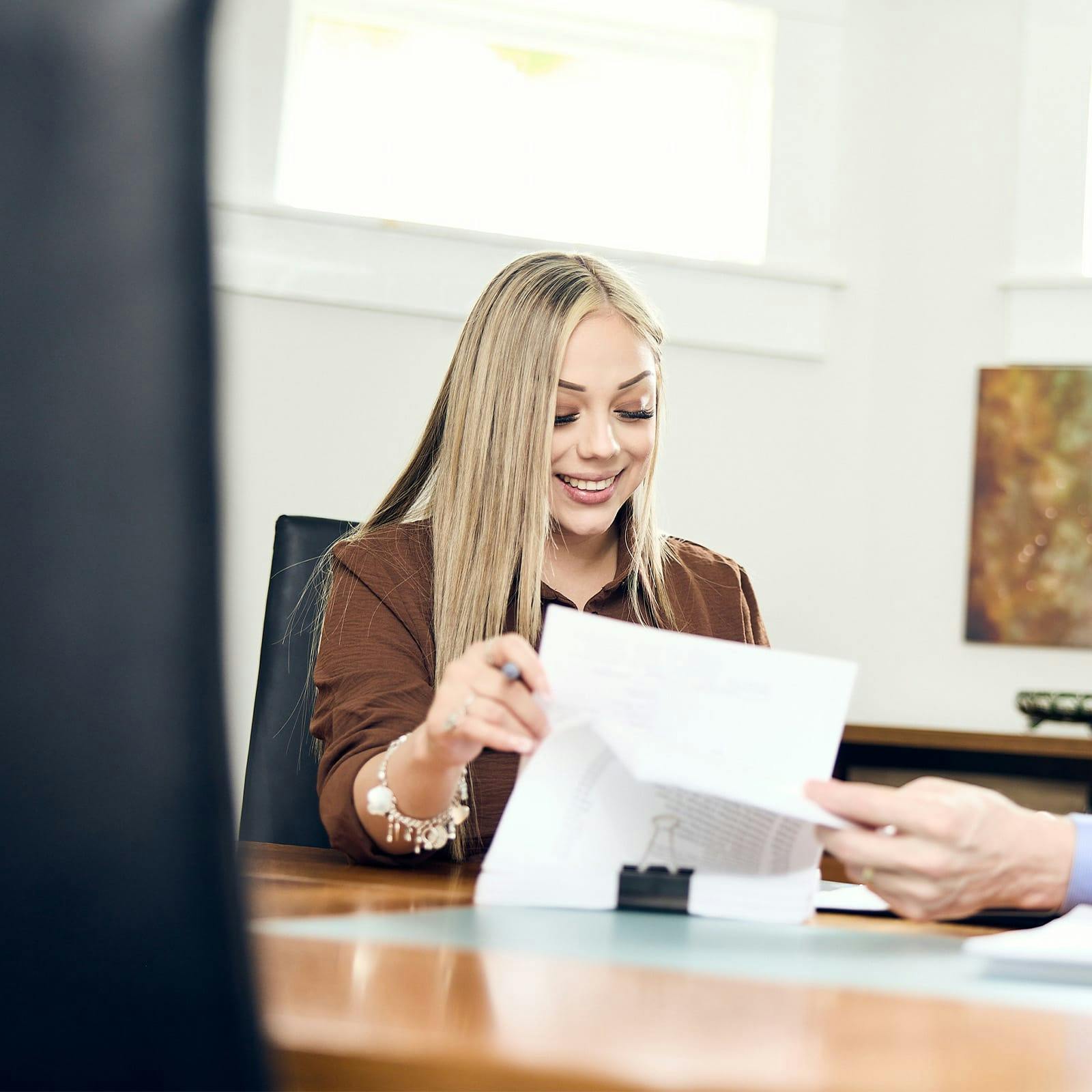woman looking through her paperwork and smiling