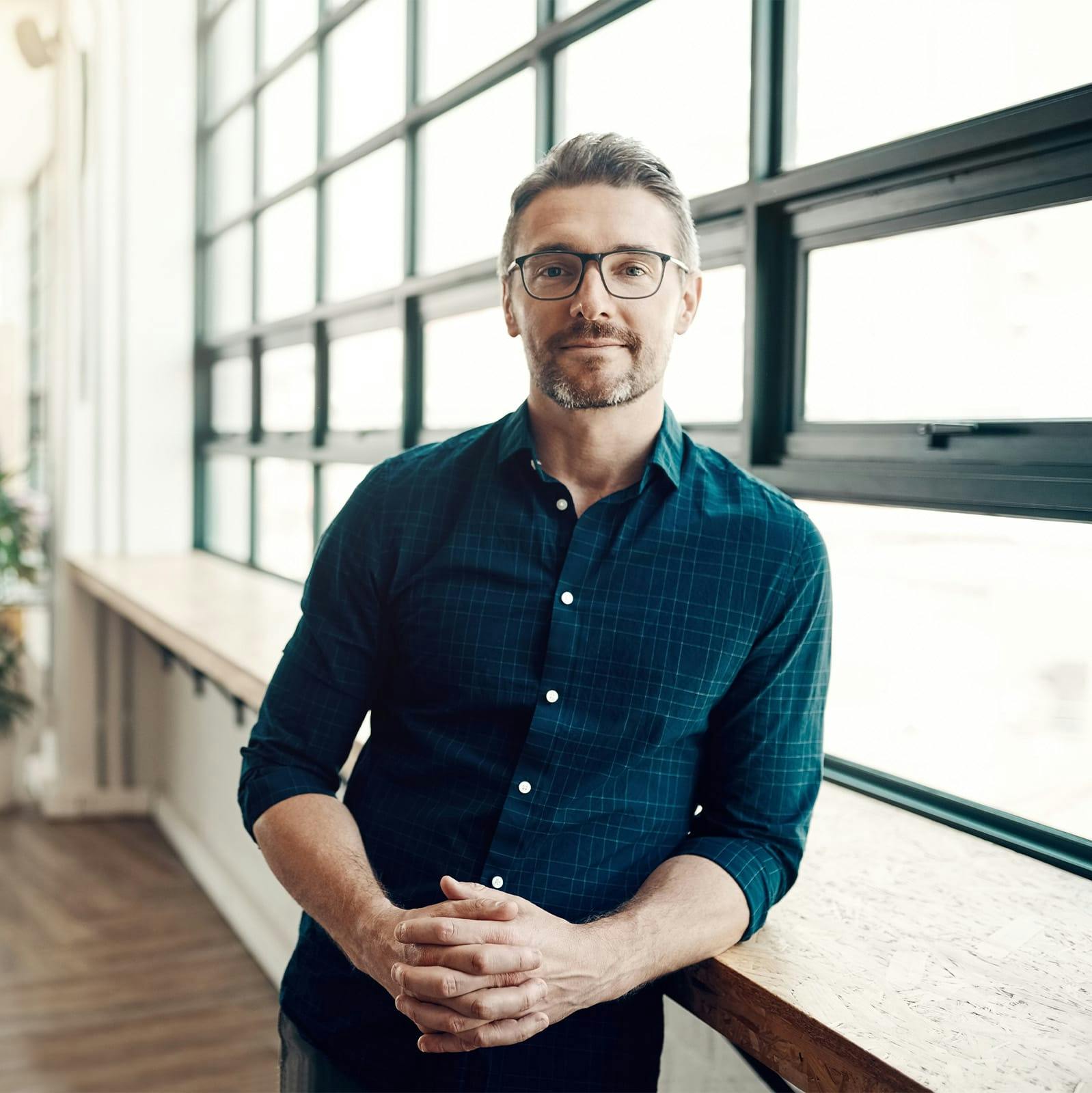 man leaning on window sill