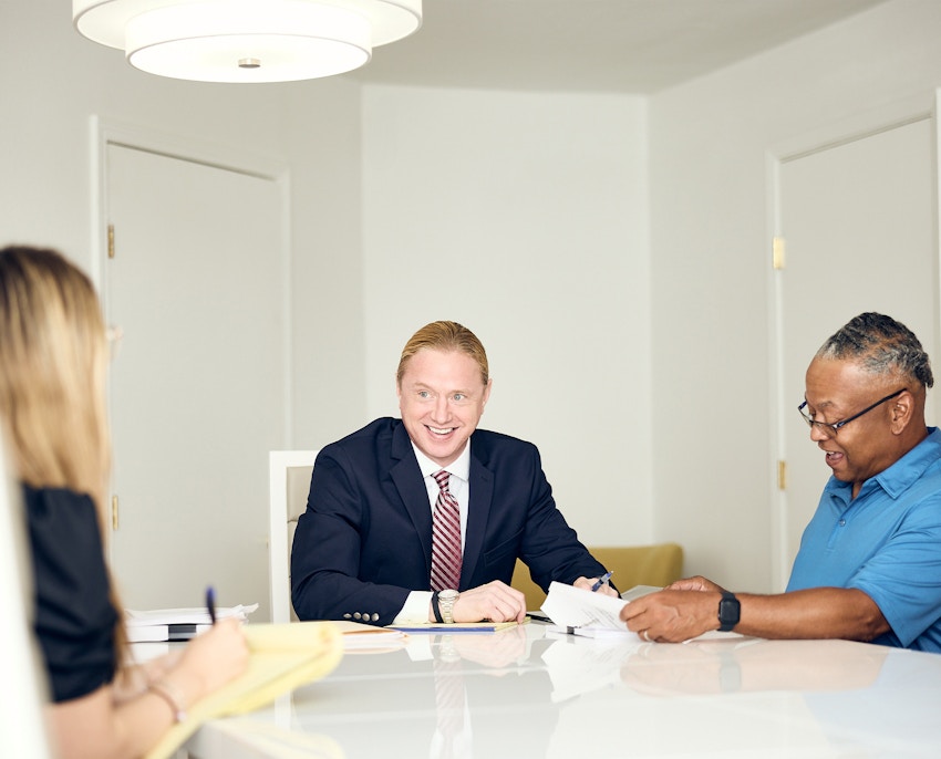 Hella speaking to client while they look at a big book