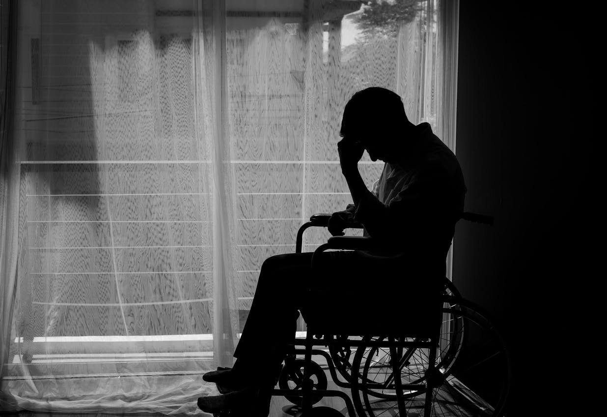 A man in a wheelchair by a window