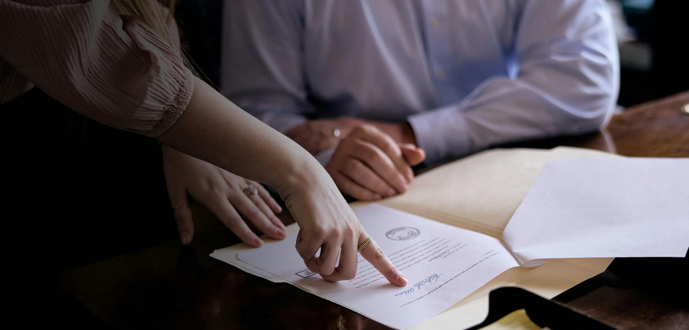 person pointing to piece of paper for client