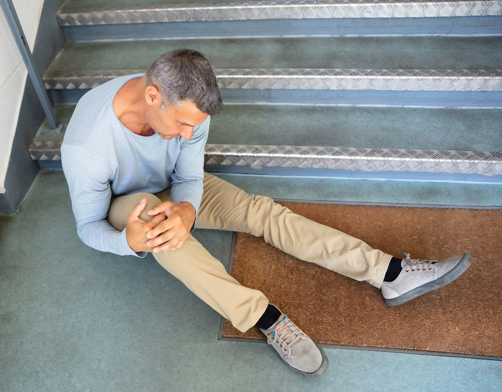 Man holding knee after falling