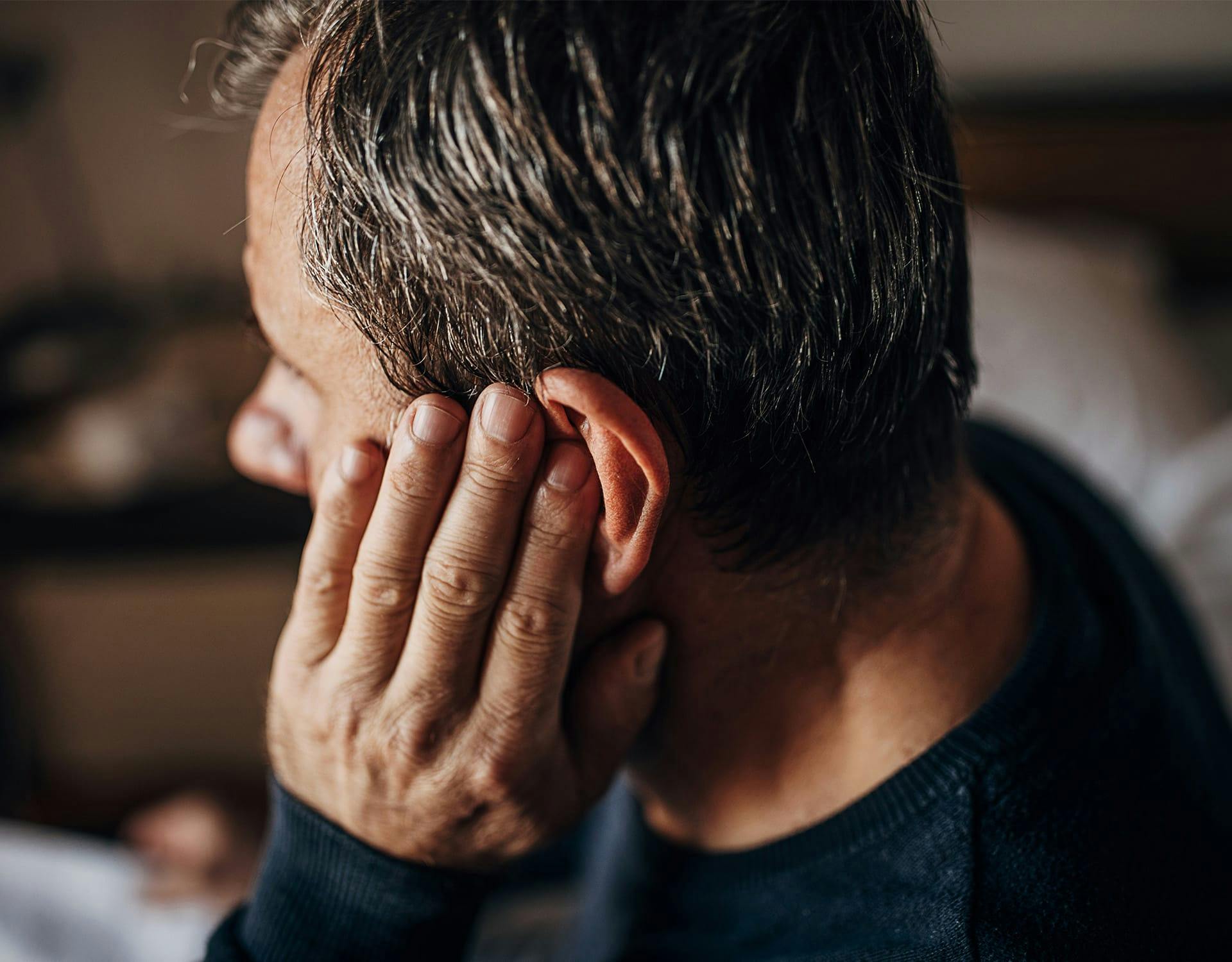 man covering his ear
