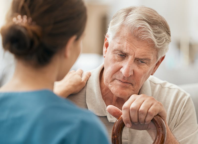 nurse helping elderly man