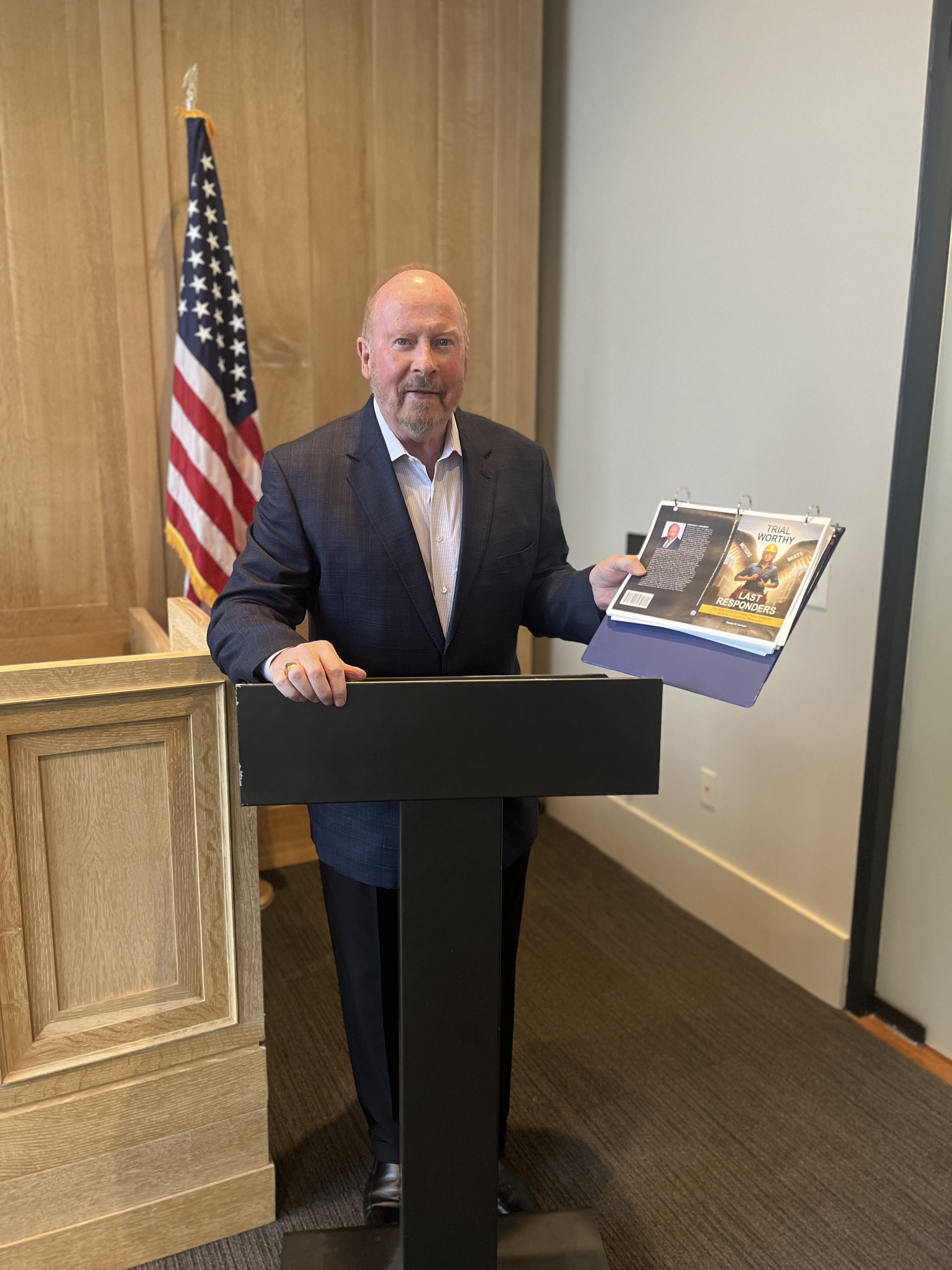 Steve Heninger at podium with new book