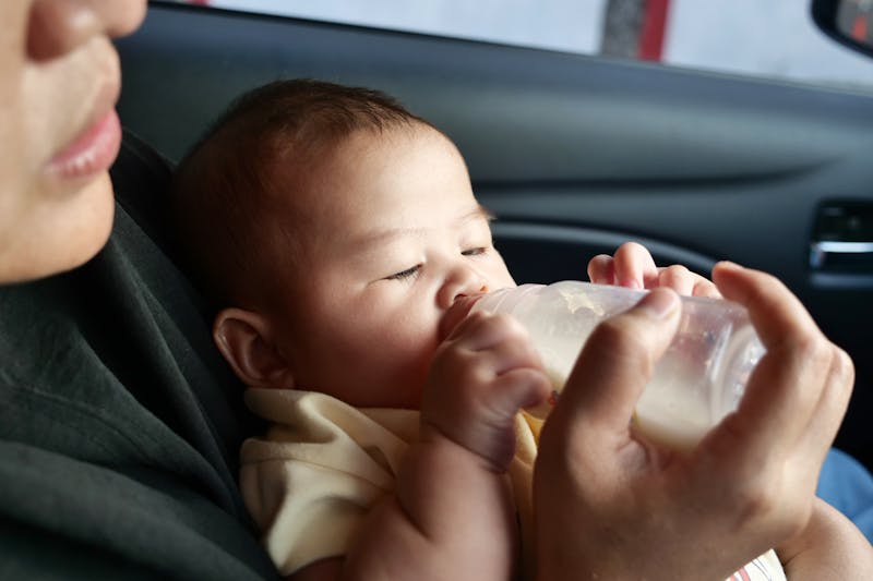 A parent feeding a baby a bottle