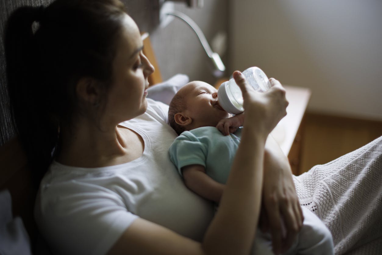 A mother giving her baby bottle of formula