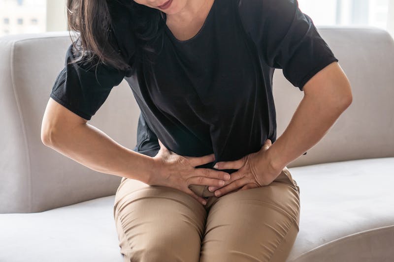 A woman pressing on her abdomen in pain