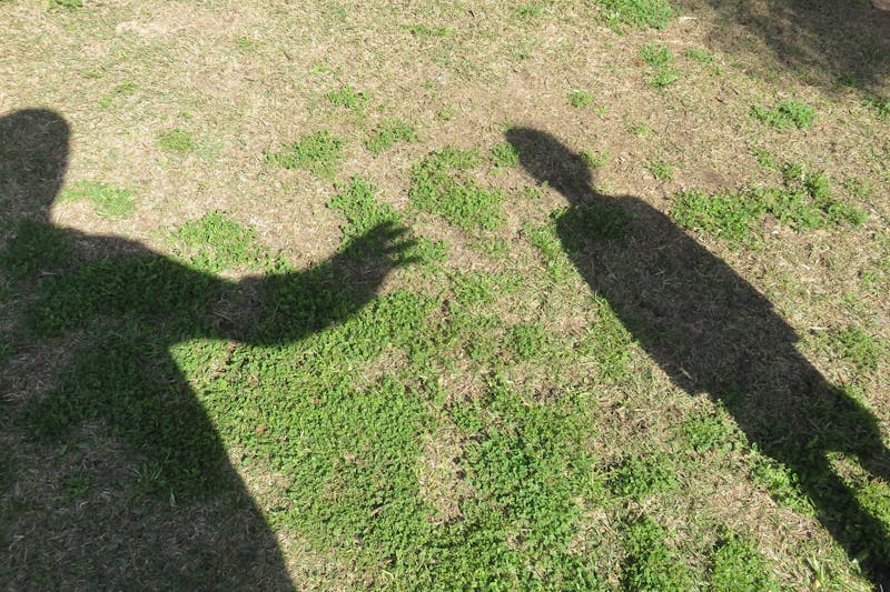 shadow of a man reaching for a kid