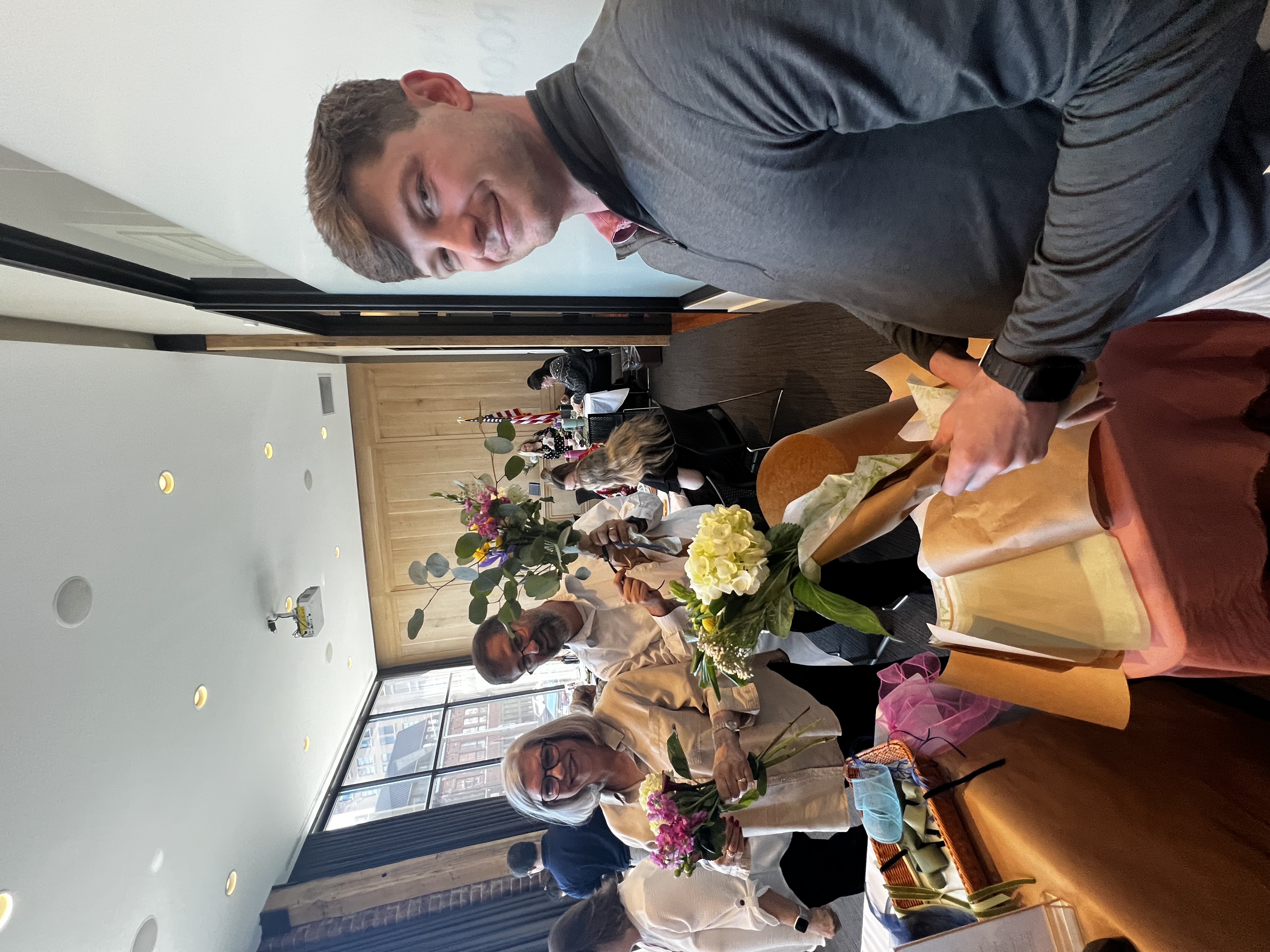 Luke and other staff members holding flowers
