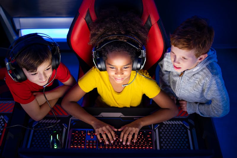 3 kids looking at a computer playing video games