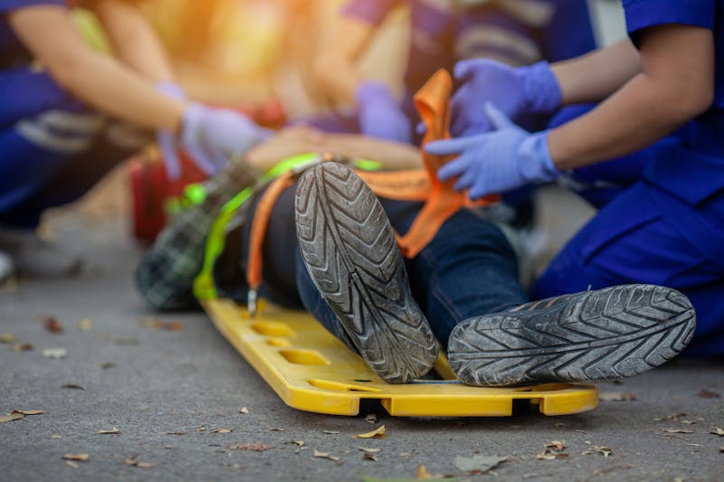 Man laying down while medical personel help him