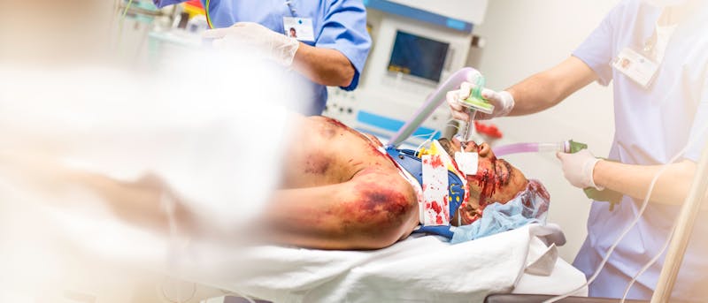 Man in a hospitalbed covered in blood
