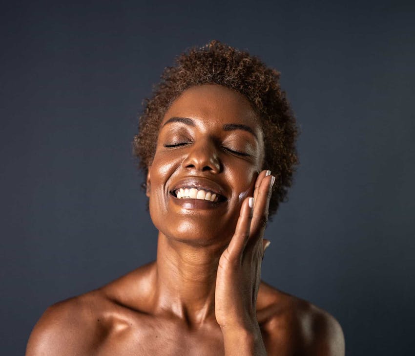 Woman smiling while touching face