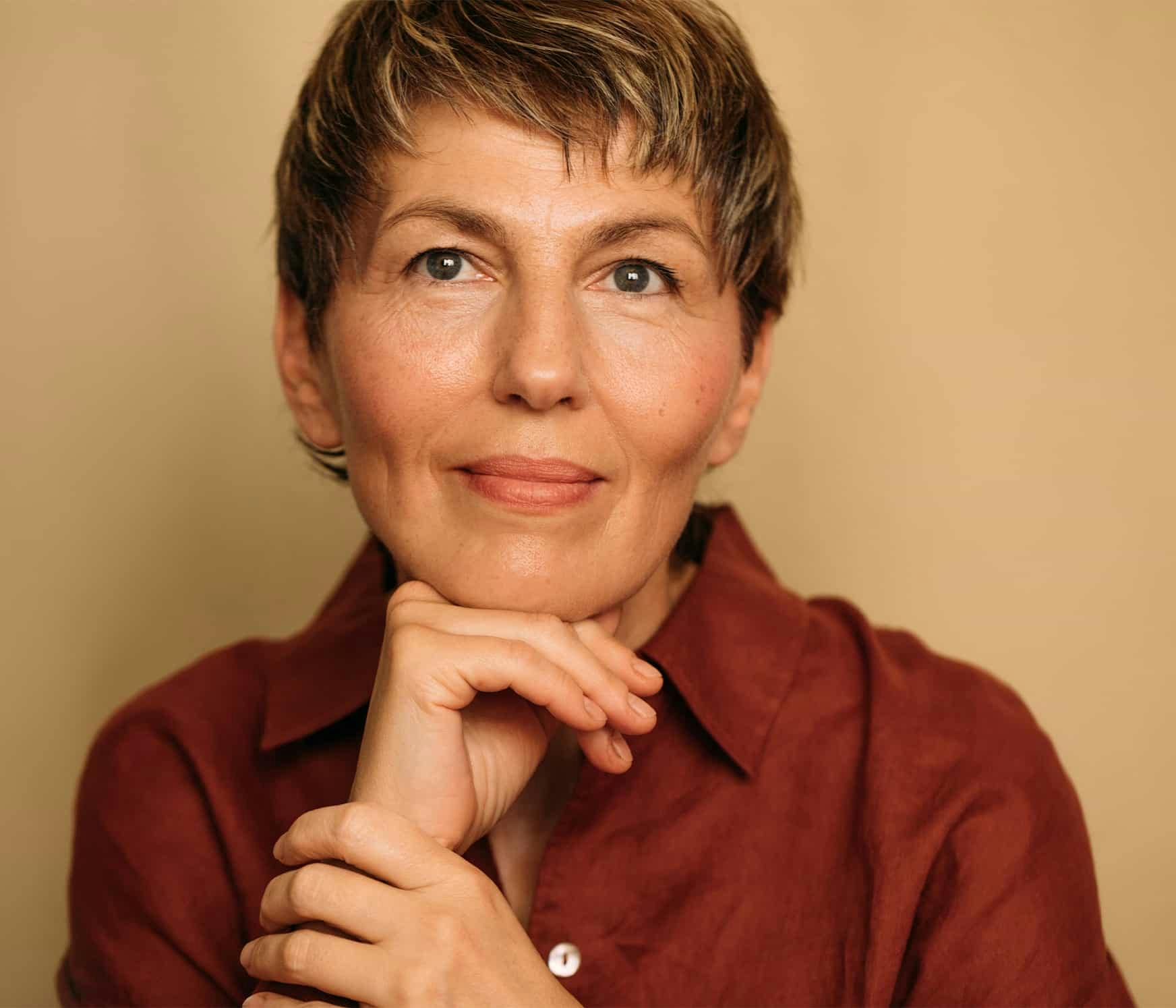 Woman with hand on hand smiling