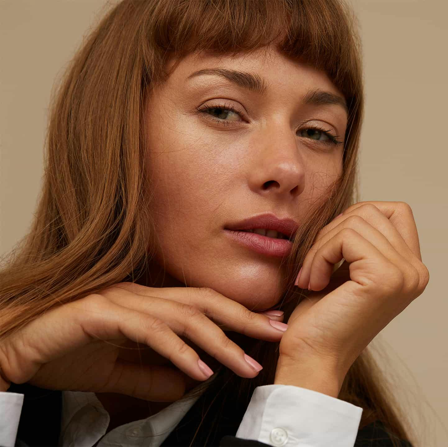 Woman with hands on chin