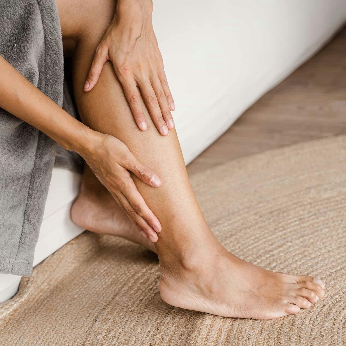 woman rubbing her legs