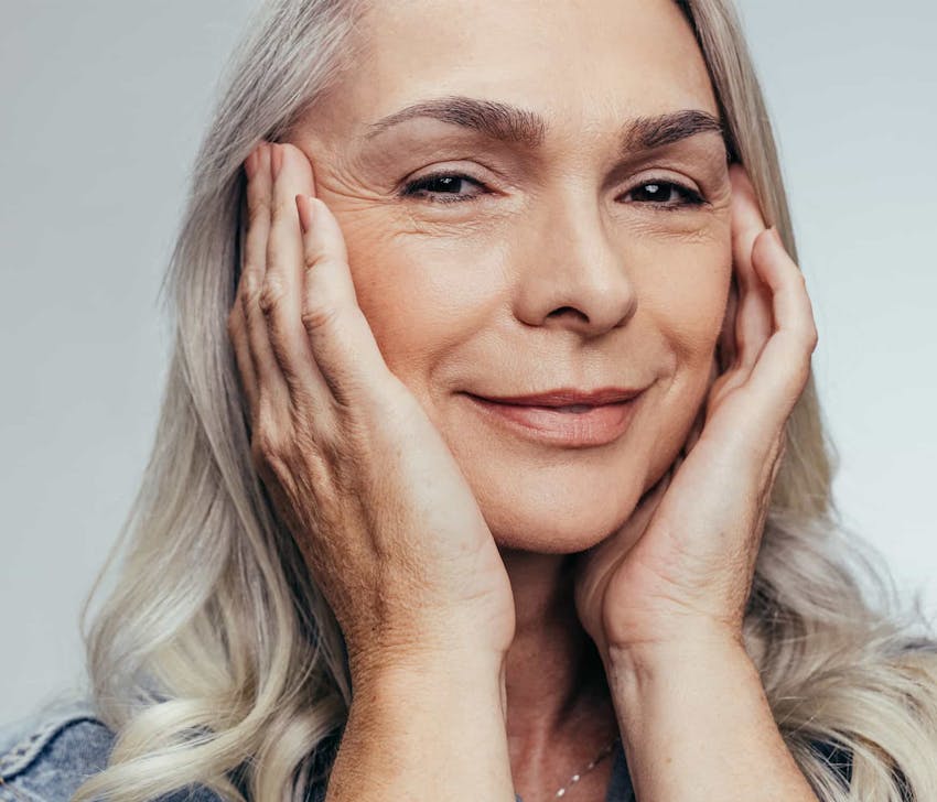 Woman with hands on cheeks smiling