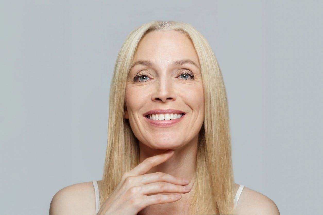 An older blonde model touching her chin