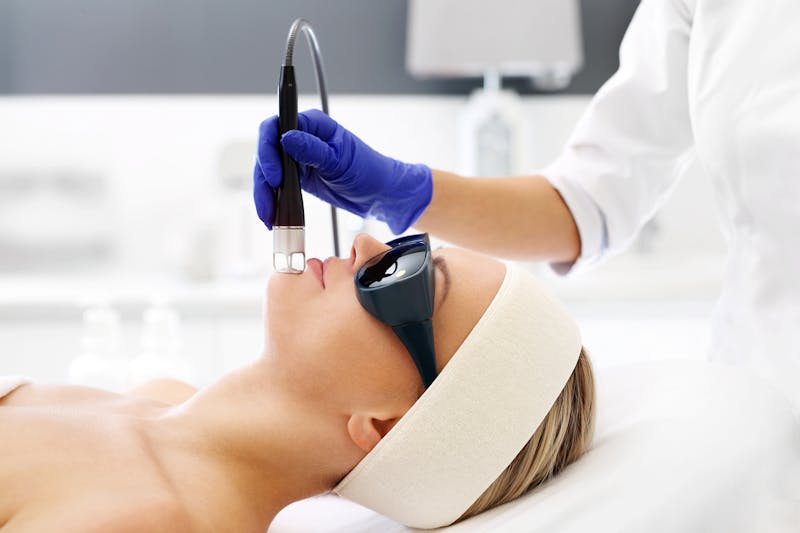 A woman in lying down during a laser treatment for her face