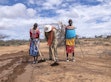 Three people digging semicircular bunds.