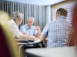 Three people discussing at a table.