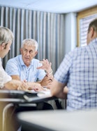 Three people discussing at a table.
