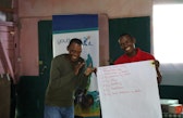 Two people smiling during a presentation