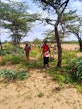 Woman in field smiling, surrounded by other women