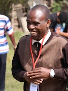 A in a brown sweater smiling